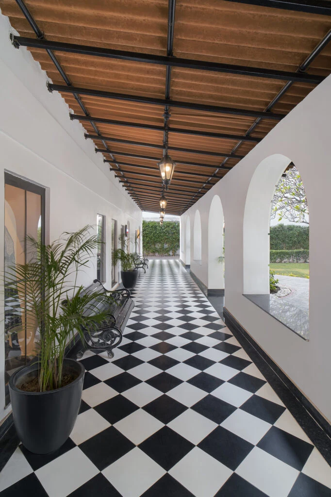 An arched corridor with a black-and-white tiled floor at Le Press