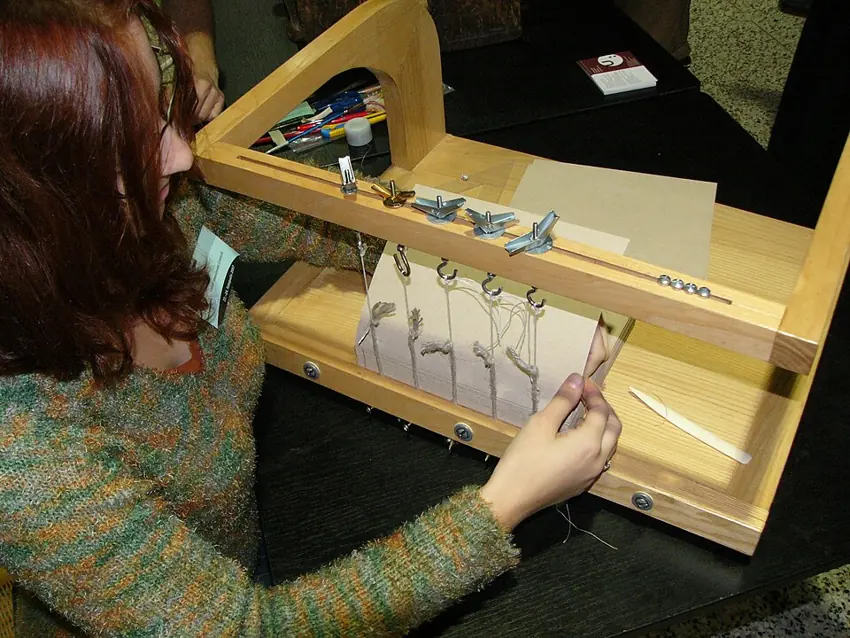Book sections being sewn on a binding frame